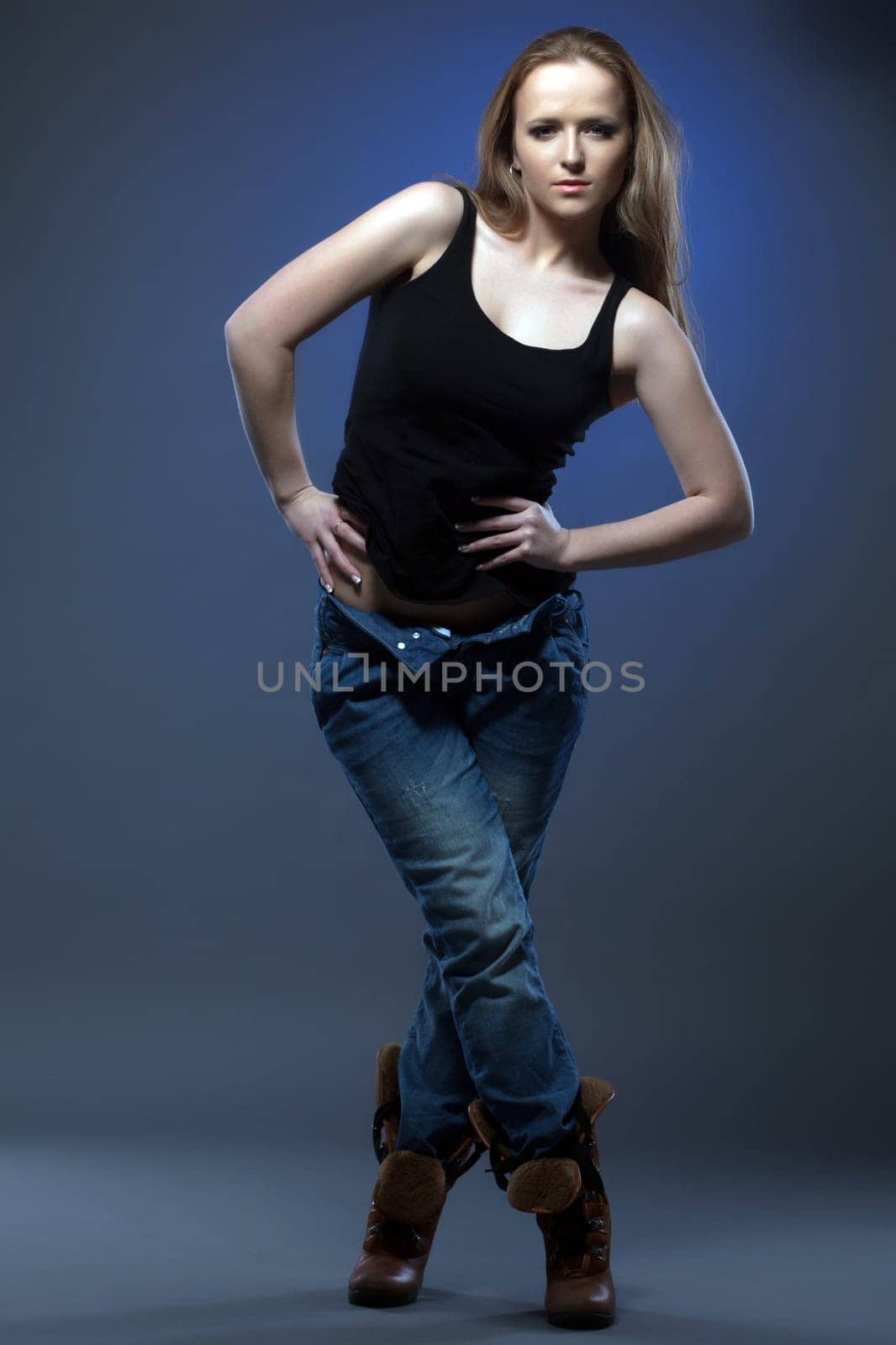 Slender young model shows trendy casual clothes in studio