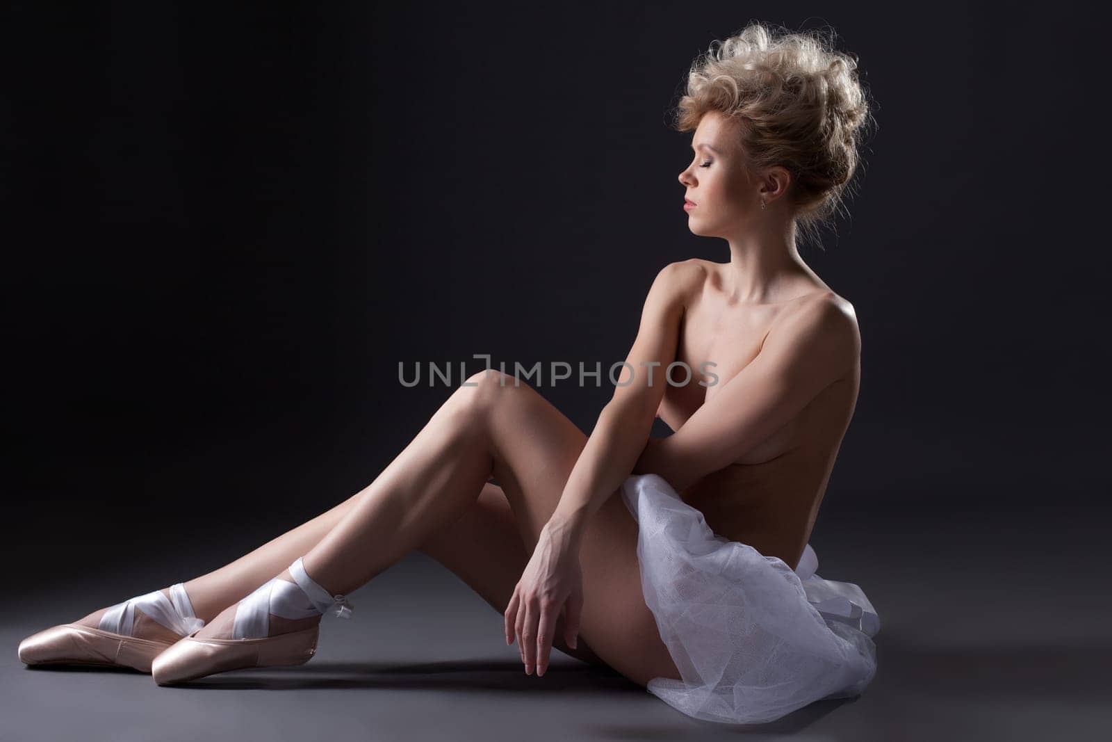 Charming young ballerina posing topless in studio, close-up
