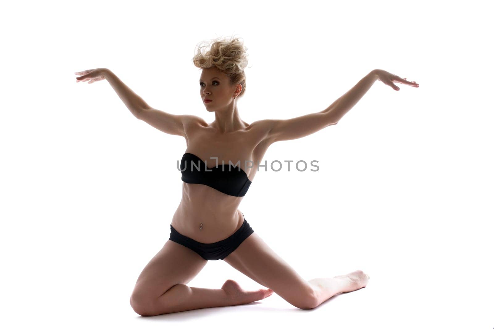 Attractive slim dancer posing in black lingerie, isolated on white