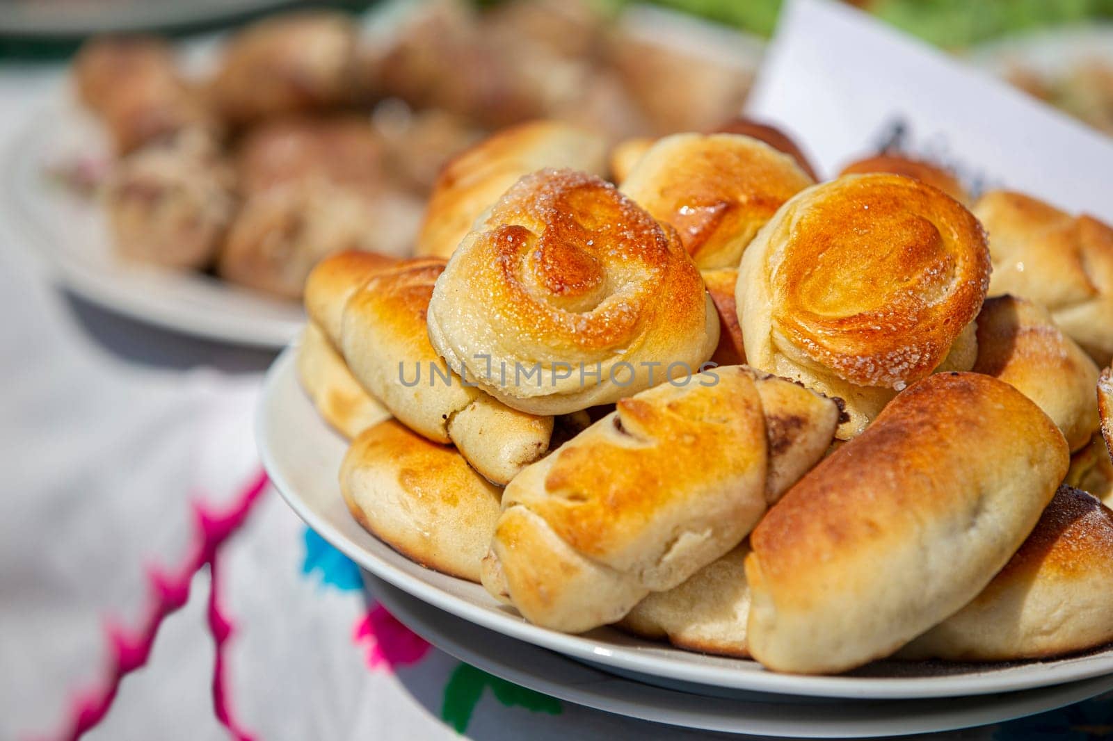 On a plate are yeast buns sprinkled with sugar.