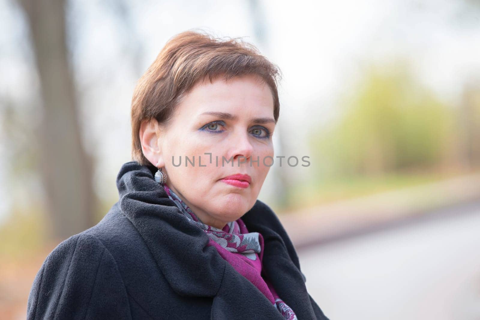 Portrait of a fifty-year-old woman with a short haircut. The face of a middle-aged woman.