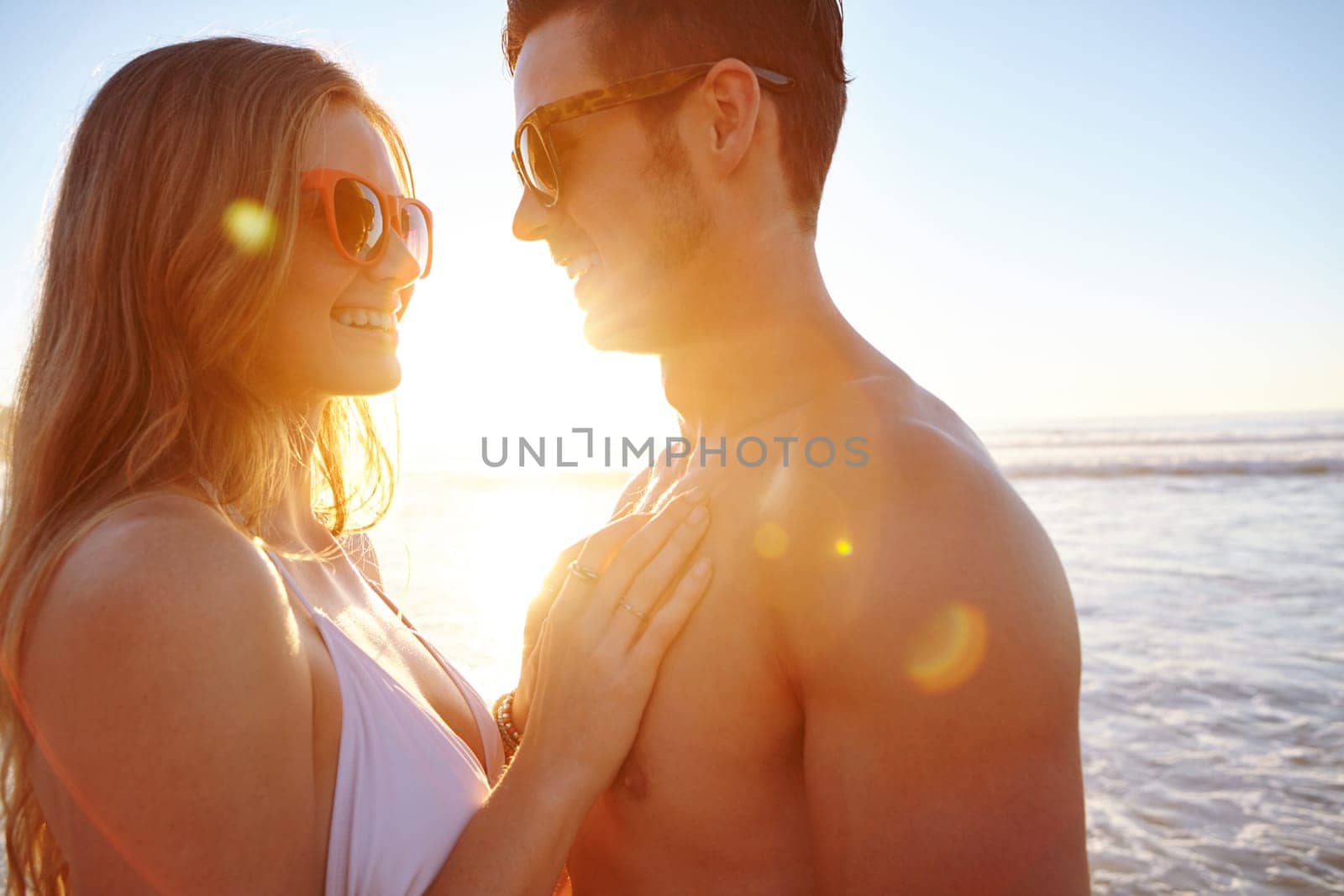 It doesnt get anymore romantic than this...a young couple enjoying a romantic moment at the beach. by YuriArcurs