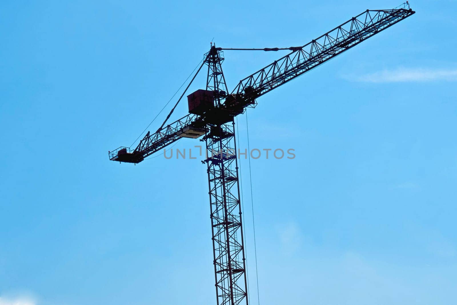 a large, tall machine used for moving heavy objects by suspending them from a projecting arm or beam.