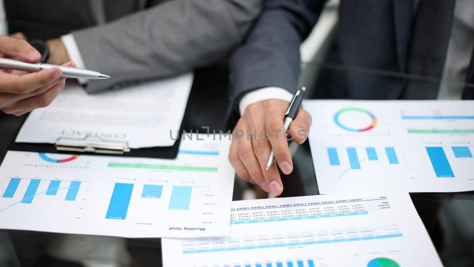 Businessman working at office desk, he is building a growing financial graph using wooden toy blocks. successful business concept