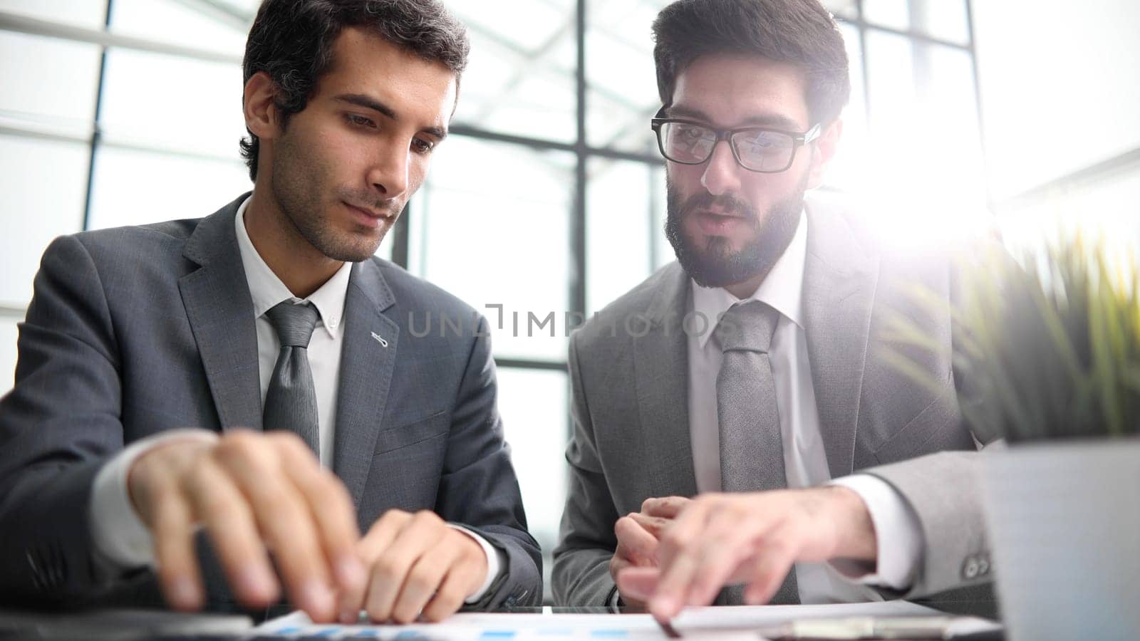 colleagues are sitting at a table in a modern office corridor