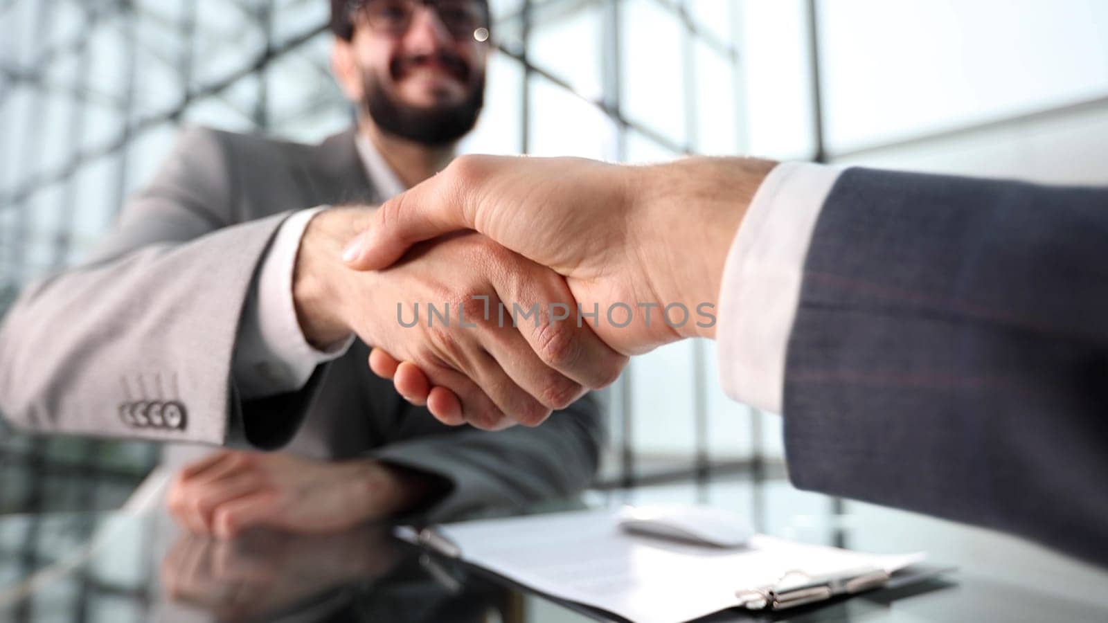 Two businessmen shaking hands at lunch meeting