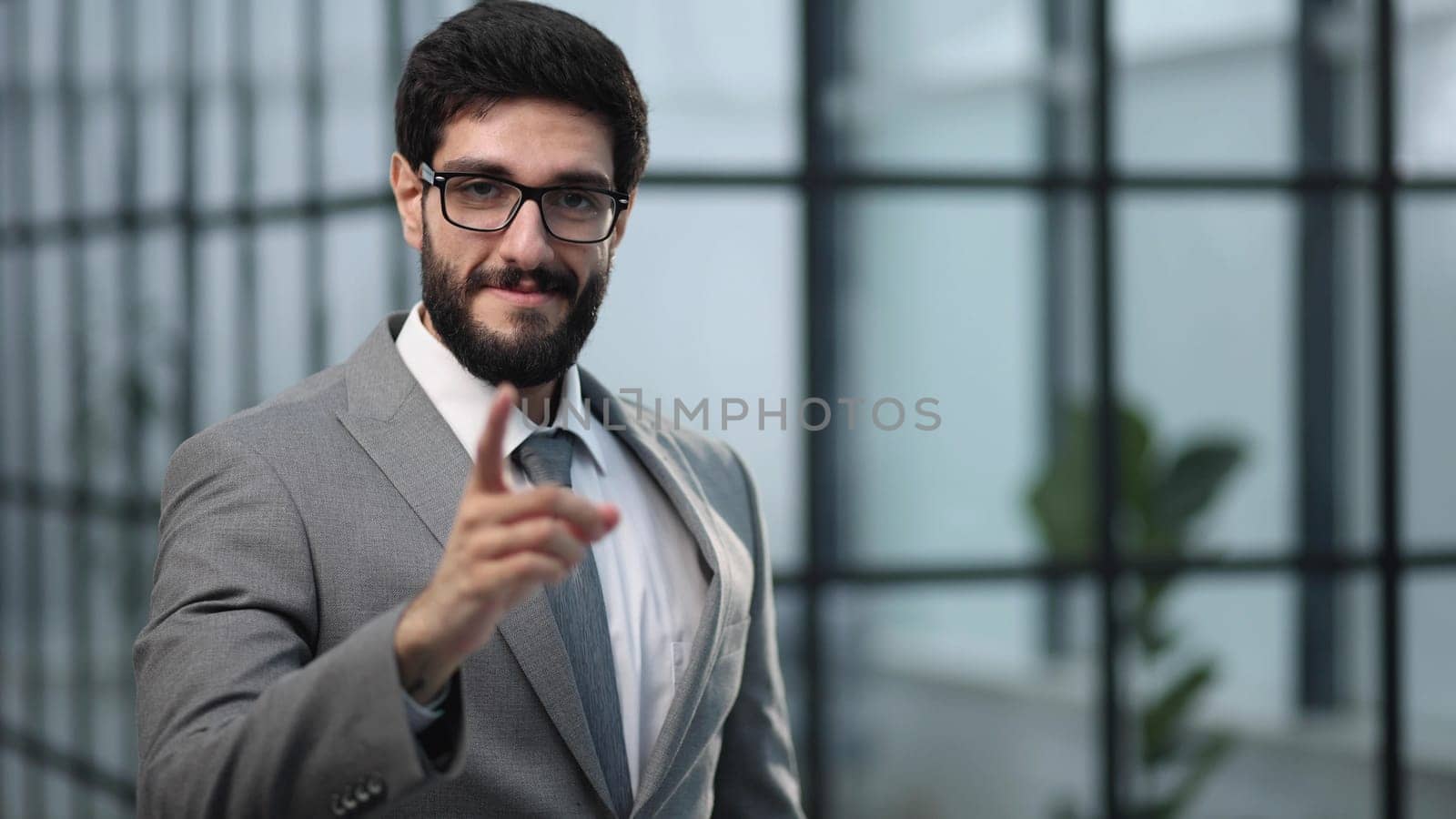 Young businessman standing in an office confidently