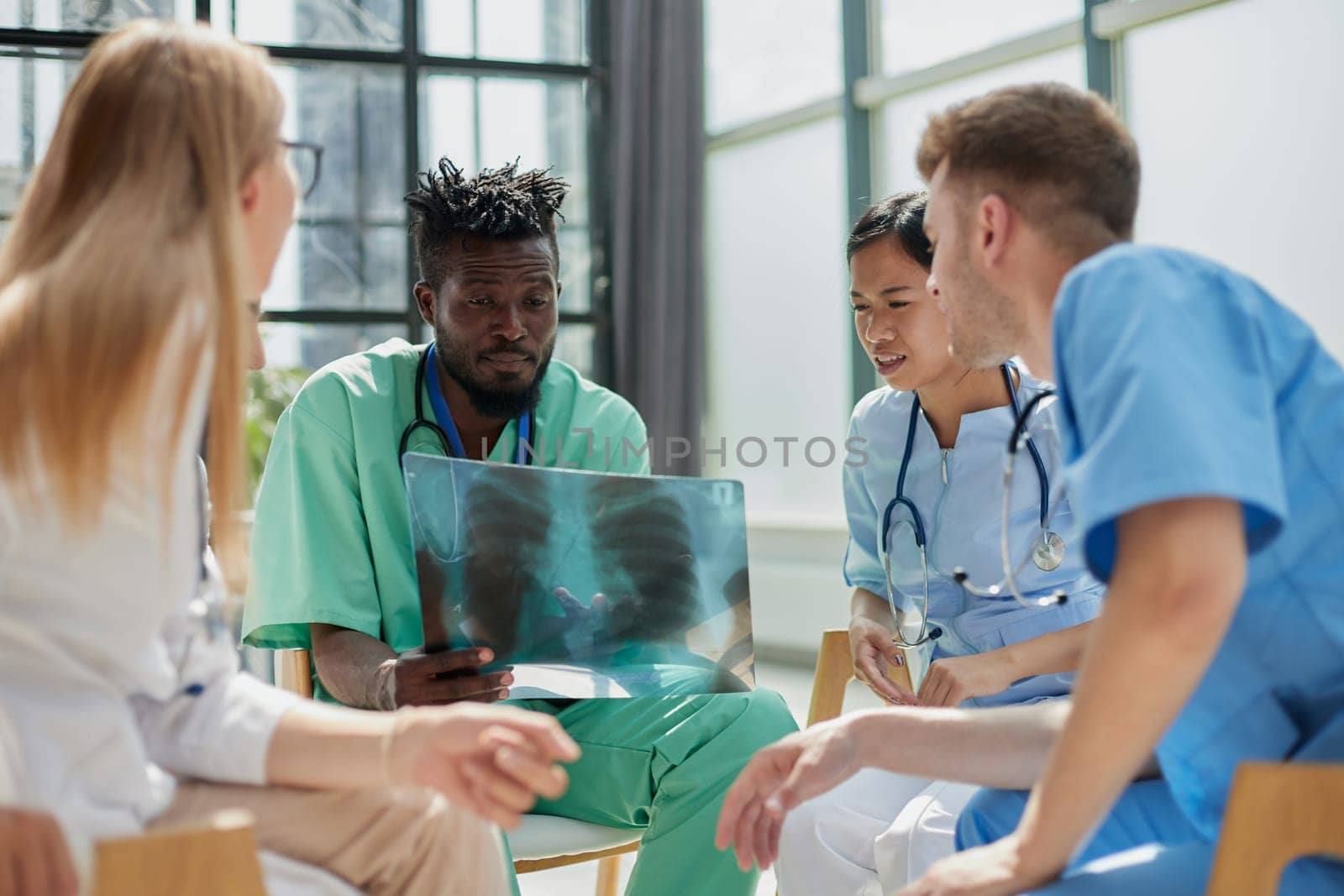 Young group of oral surgeons looking at x-ray while preparing for surgery procedure.