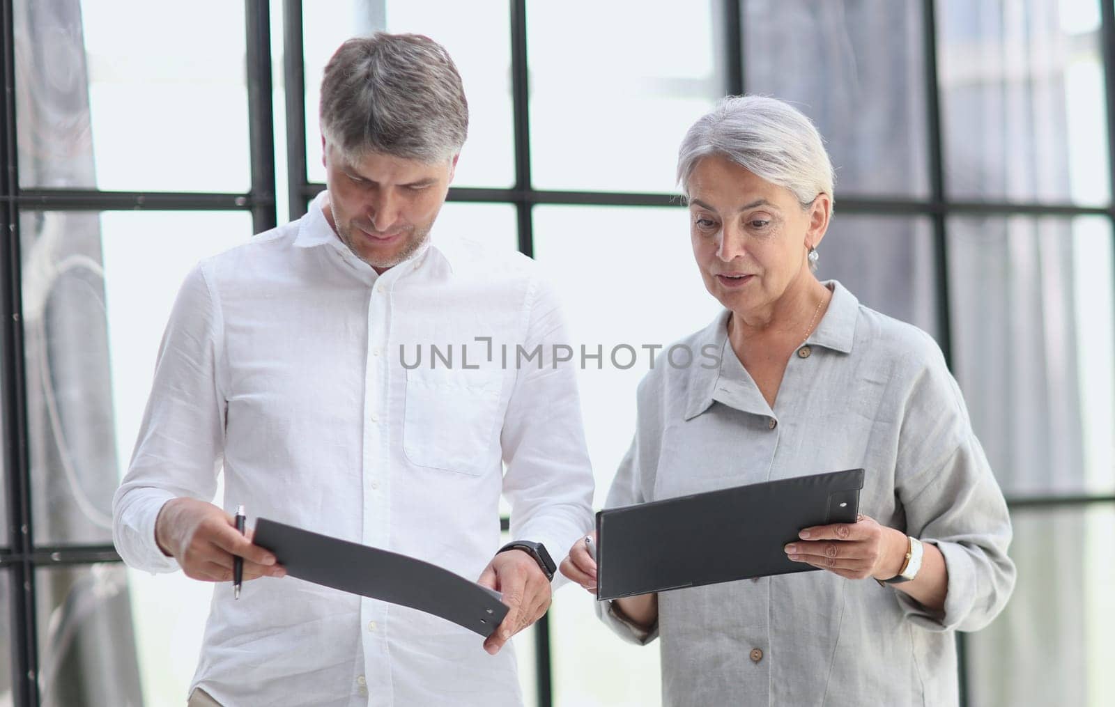 Businessman and businesswoman smiling looking at phone