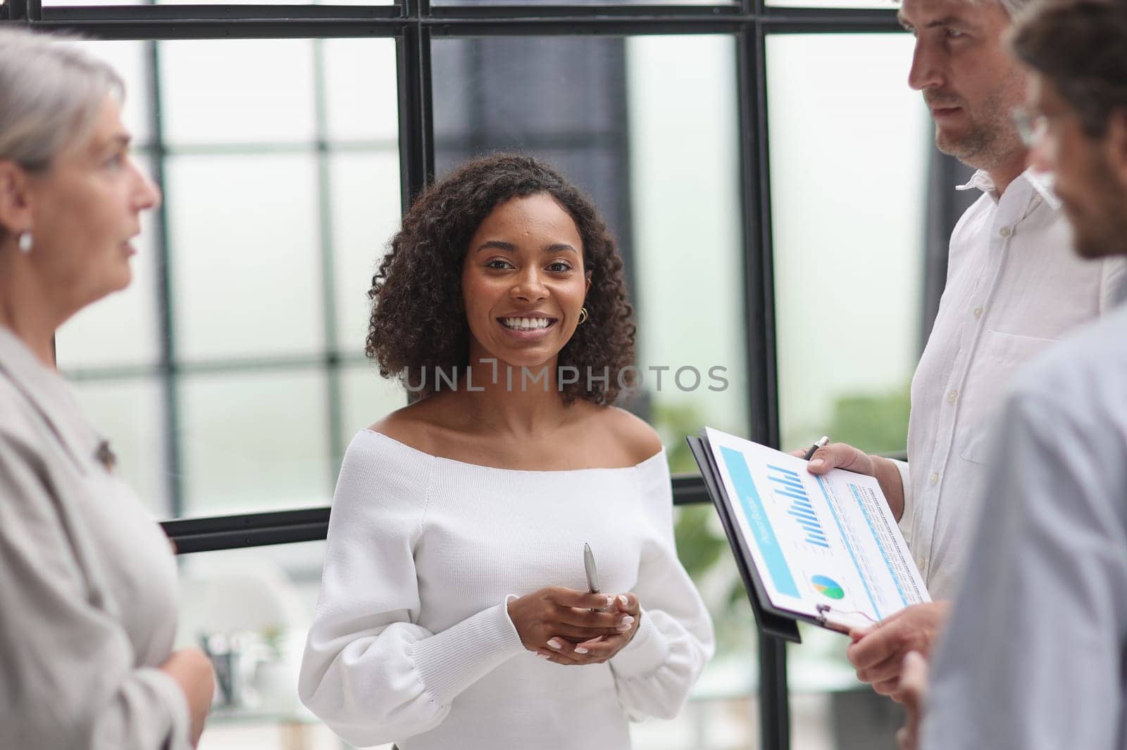 Negotiations in the office. Smiling businesswoman talks with colleagues