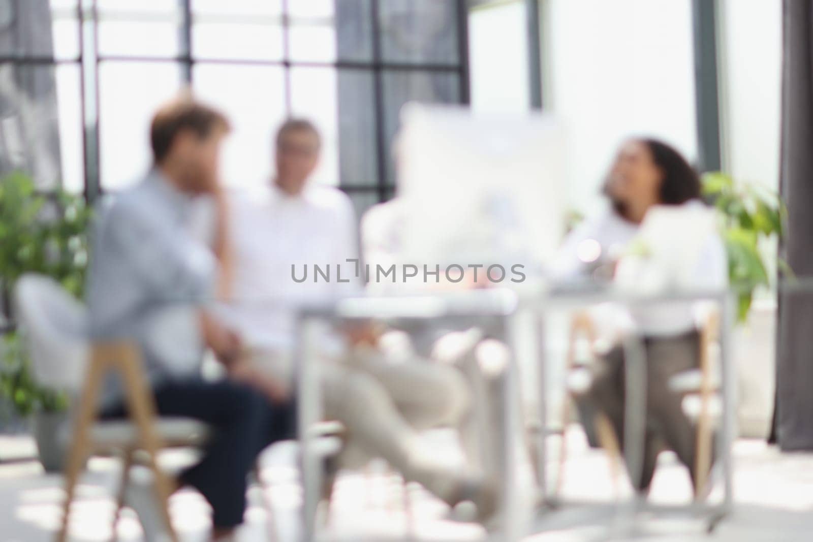 Conversation between managers and employees in the office. Blurred photo.