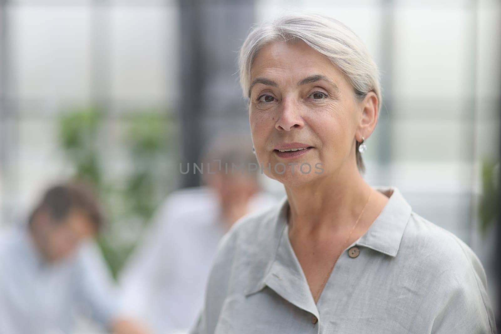 close-up mature woman holding a cup in the office.