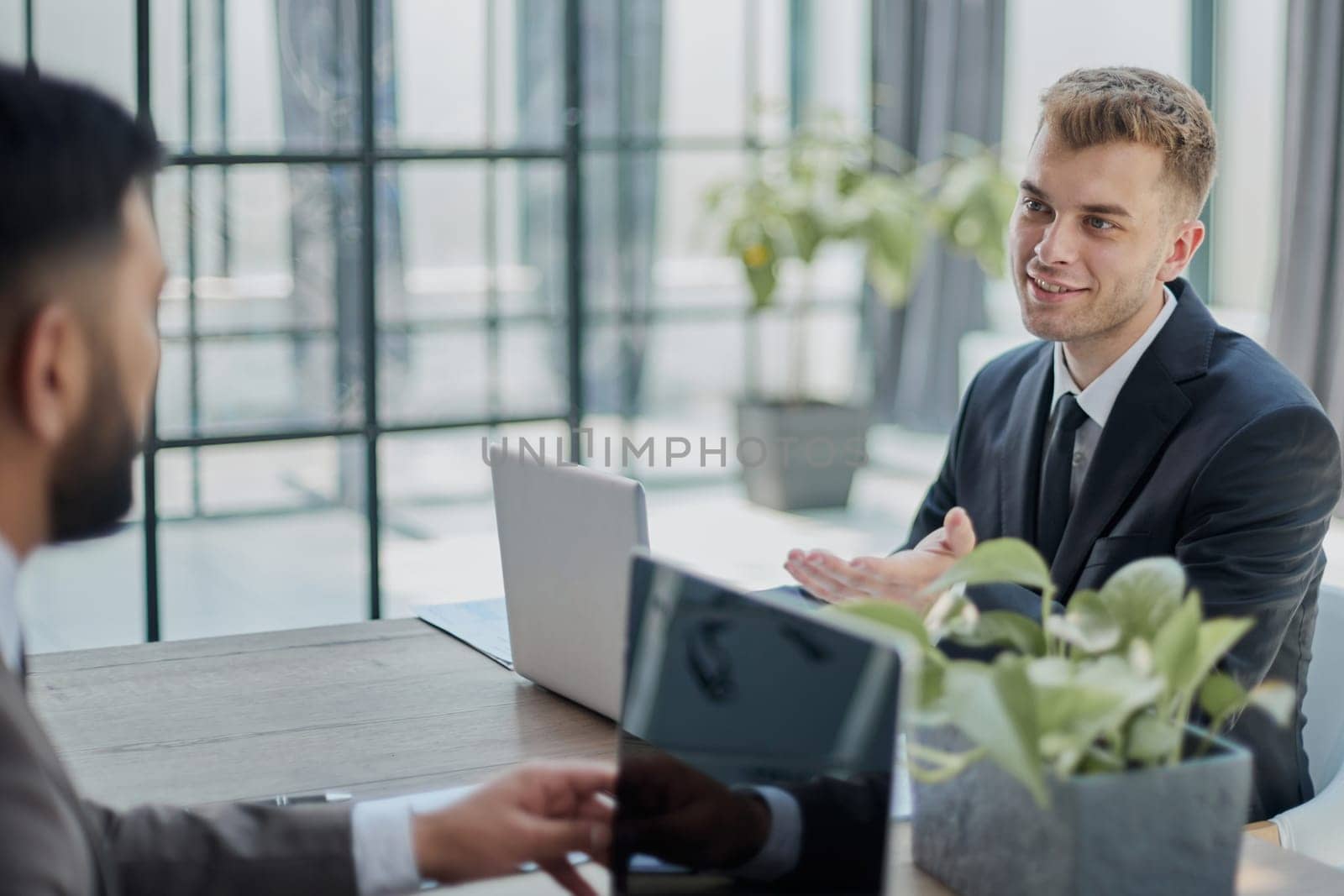 Discussing the problem. Two confident business man discussing something on the computer
