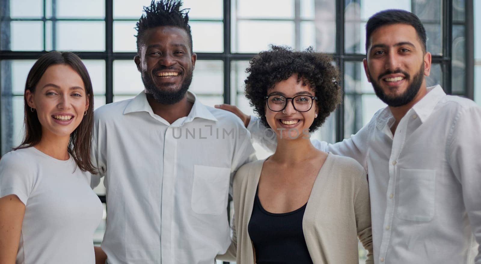 Portrait of successful creative business team looking at camera and smiling. Diverse business people standing together at startup.