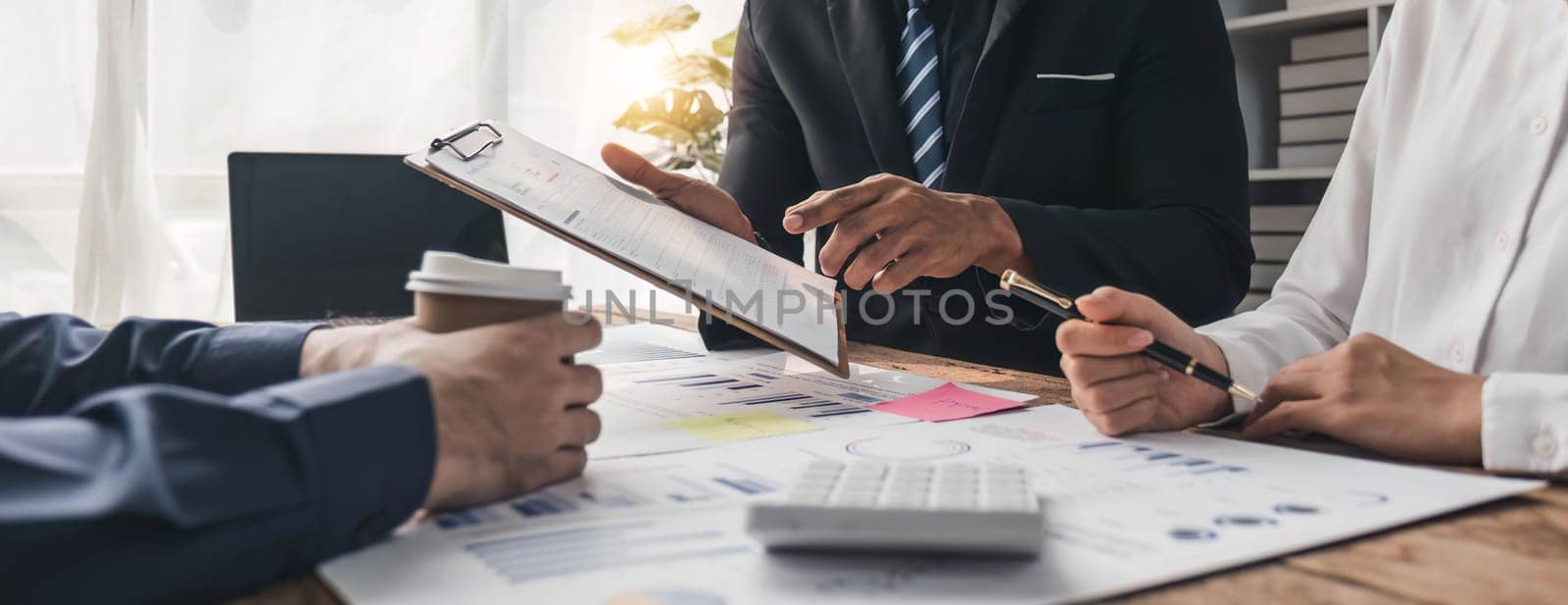 Business People Meeting using laptop computer,calculator,notebook,stock market chart paper for analysis Plans to improve quality next month. Conference Discussion Corporate Concept
