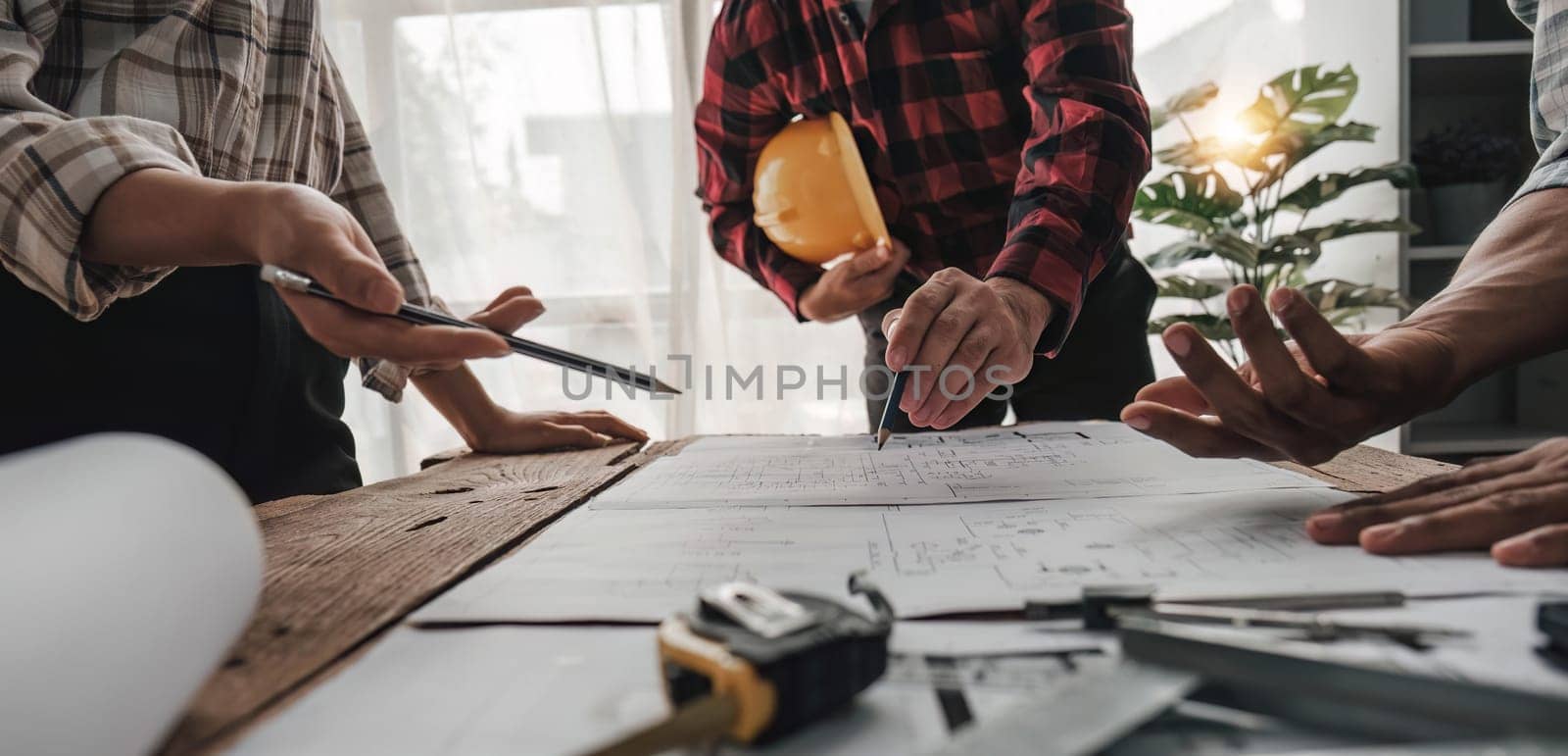 Civil engineer teams meeting working together wear worker helmets hardhat on construction site in modern city. Foreman industry project manager engineer teamwork. Asian industry professional team