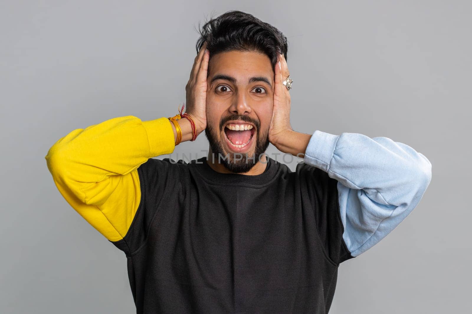 Dont want to hear and listen. Frustrated annoyed irritated indian man covering ears gesturing No, avoiding advice ignoring unpleasant noise loud voices. Handsome hindu guy alone on gray background