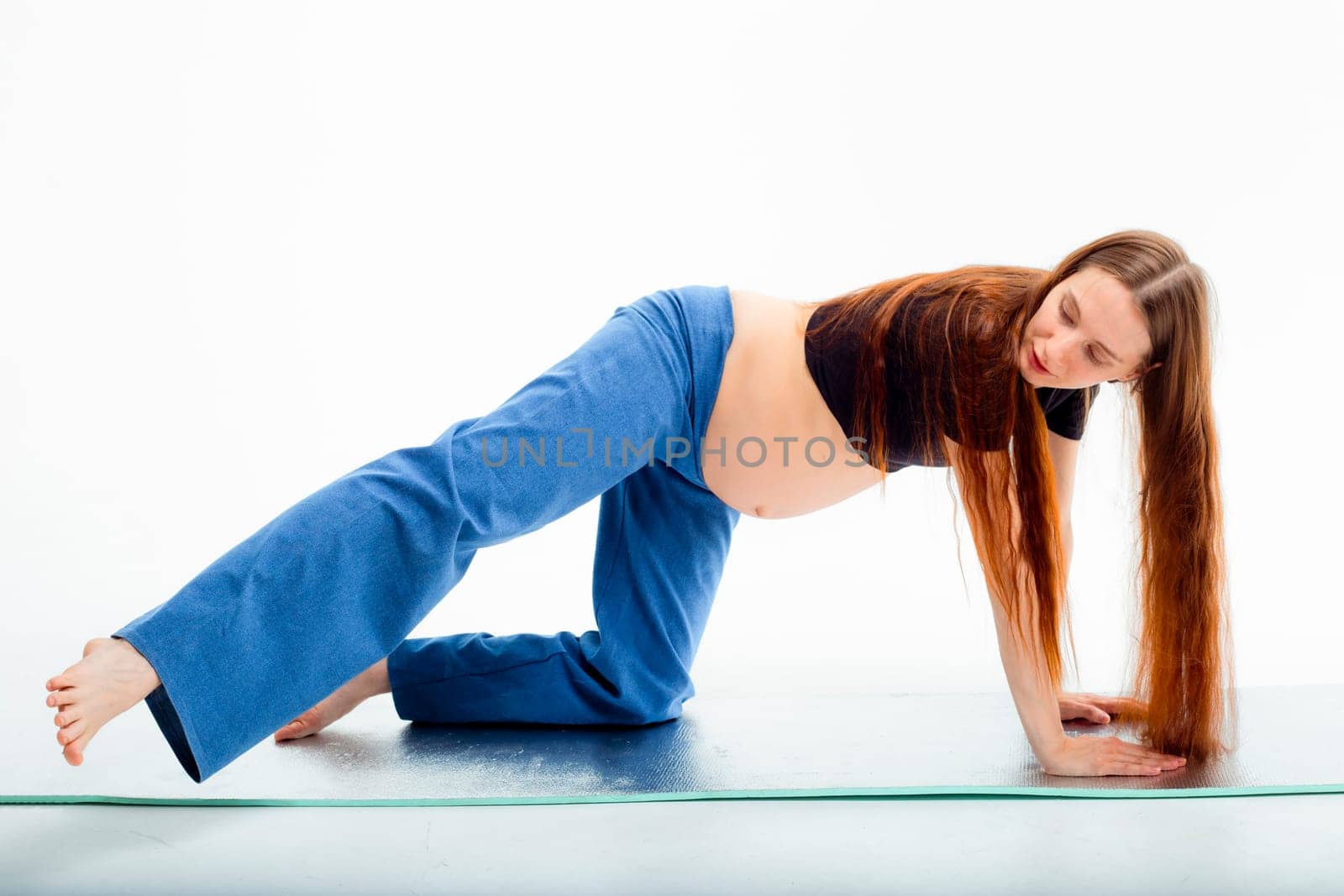 Pleasant pregnant woman posing in profile and trying yoga Young happy expectant relaxing, thinking about her baby and enjoying her future life. Motherhood, pregnancy, yoga concept.