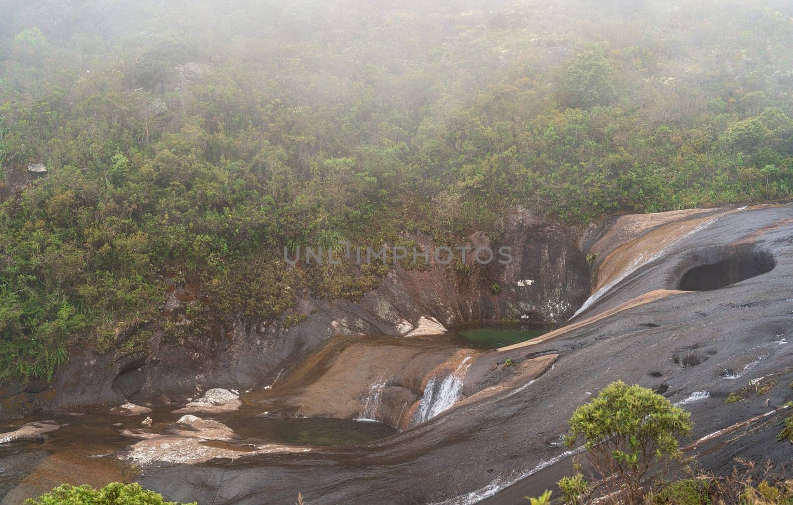 Spectacular colored pools formed by the solid rock in the high jungle river basin, surrounded by a mystical mist due to the humid forest.