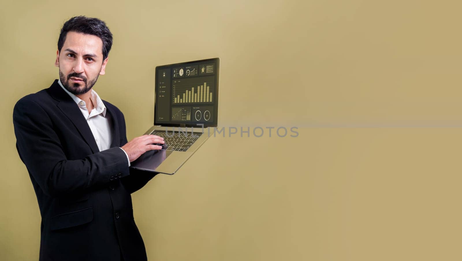 Successful businessman in black suit holding laptop. Fervent by biancoblue