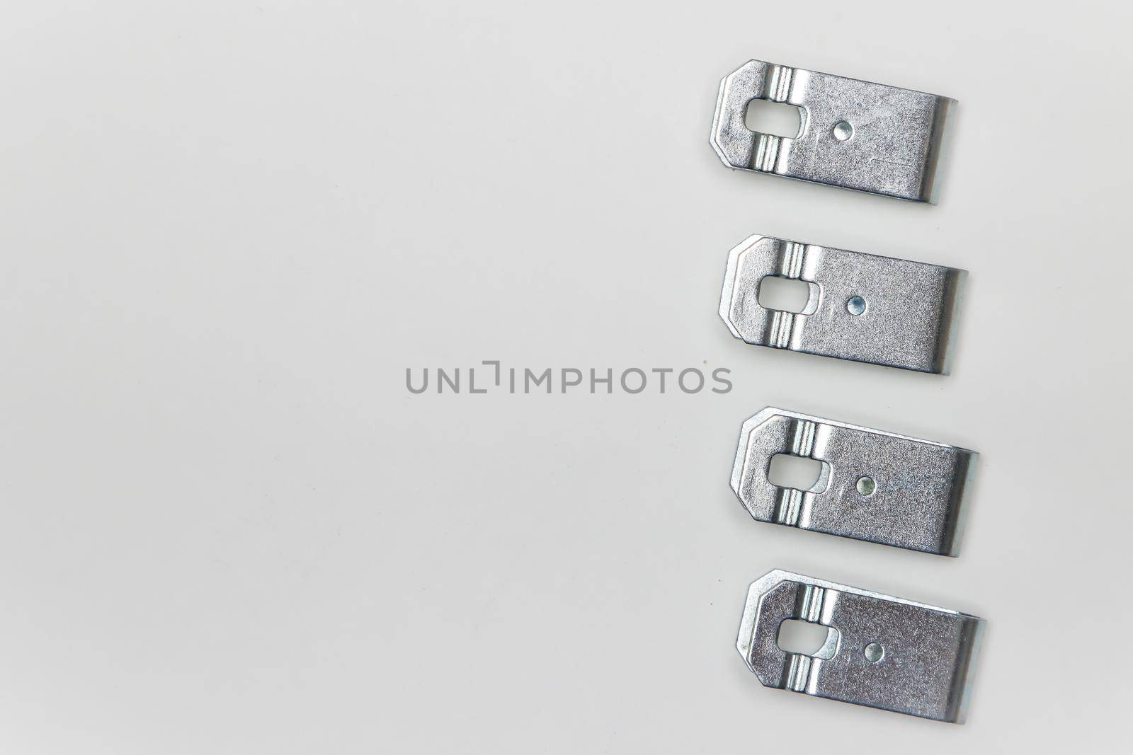 Repair kit for brakes, four metal plates - clips on the side. Set of spare parts for car brake repair. Details on white background, copy space available. UHD 4K.