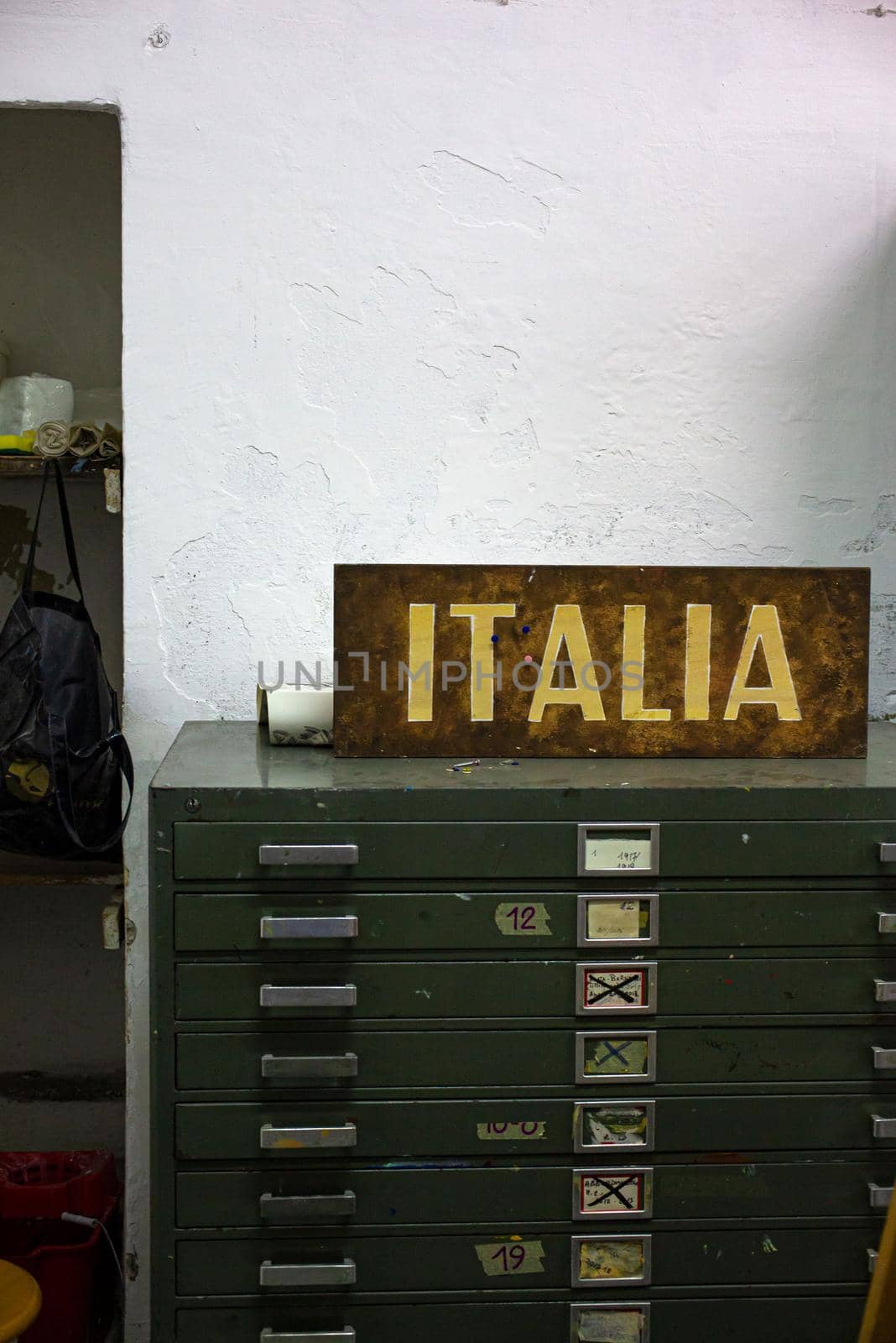 Old chest of drawers with a sign written with the word Italia