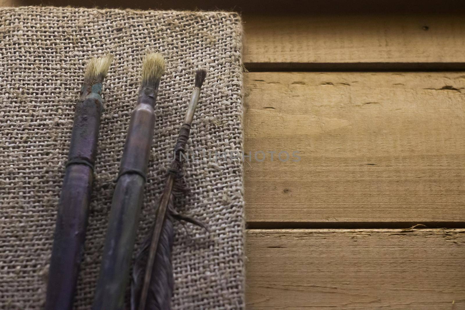 Old artist brushes on a wooden table, copy space
