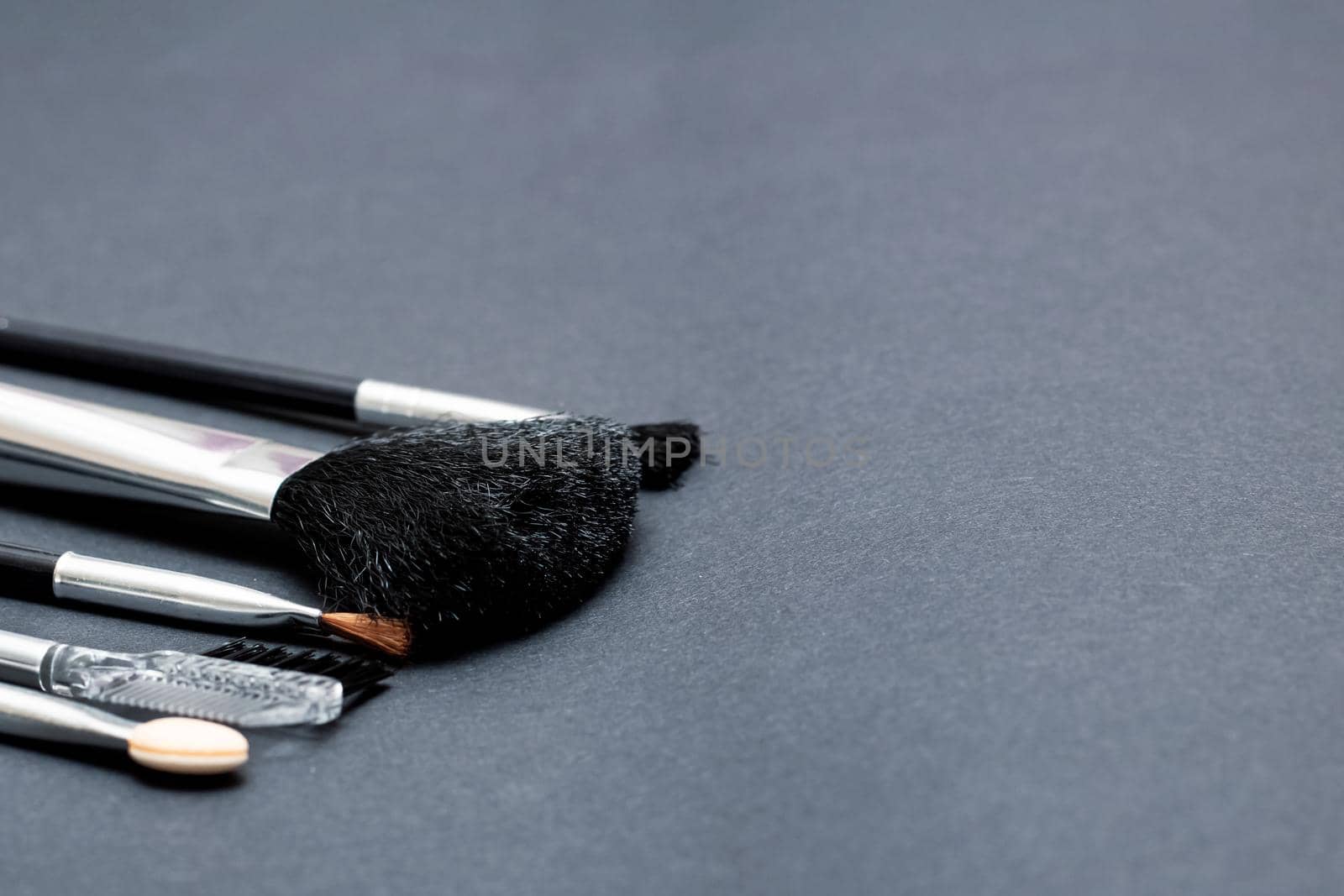 Makeup brushes on a gray background copy space