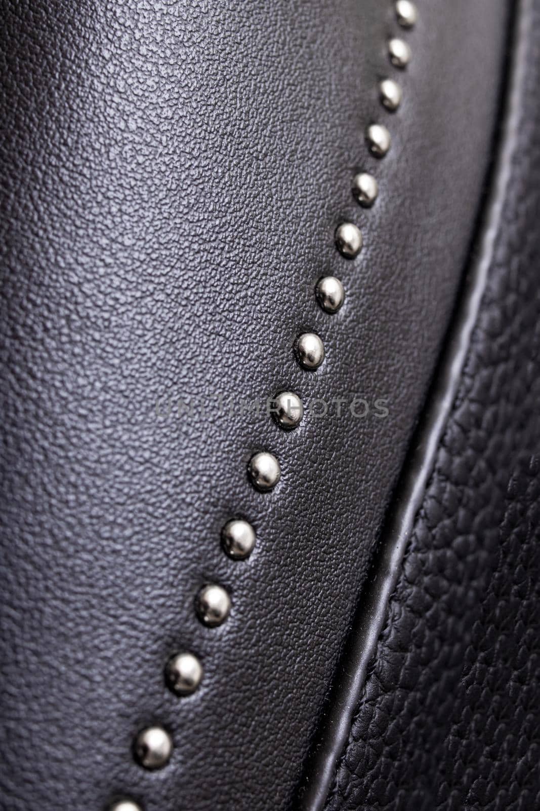 Black leather material with metal rivets close up