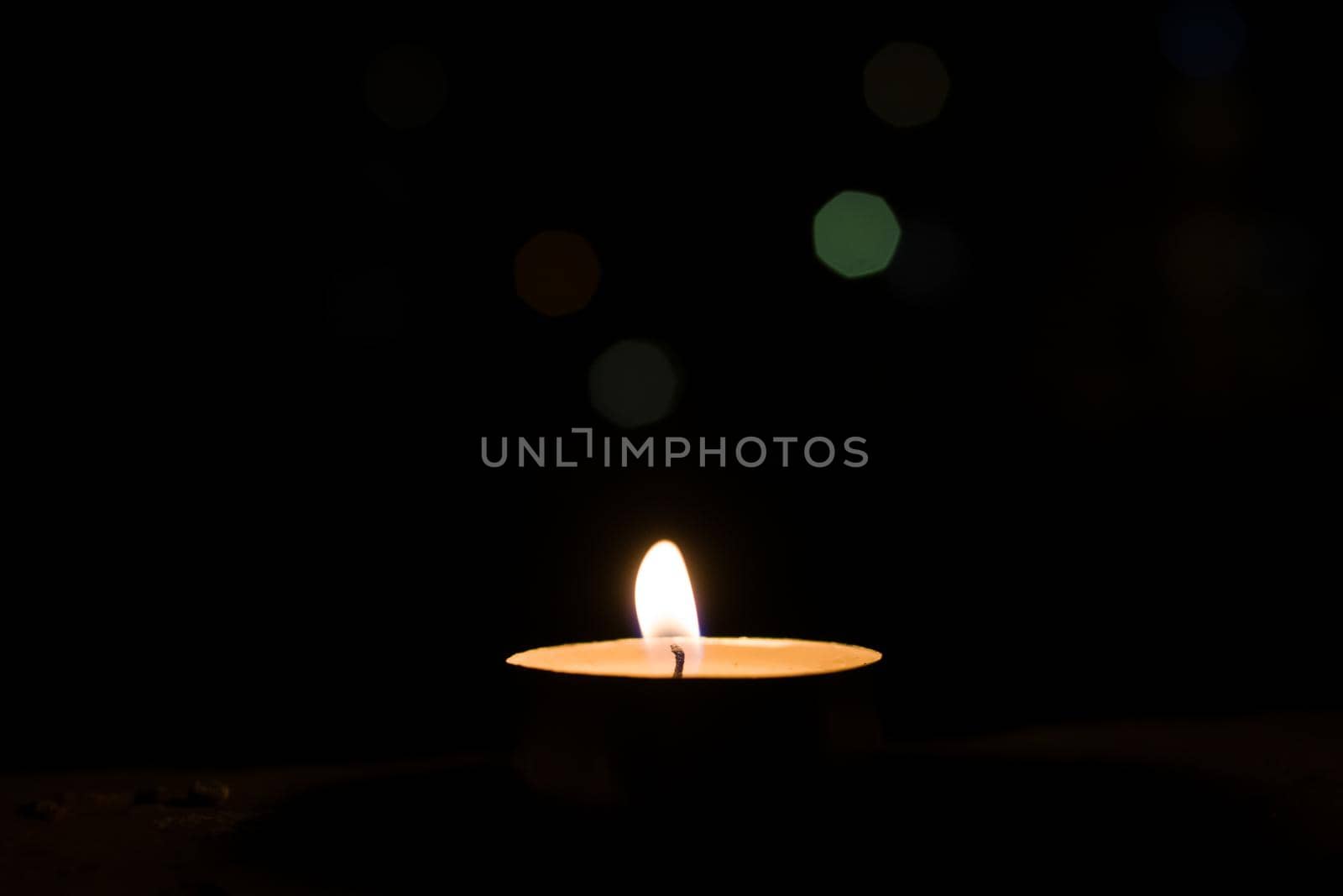 Burning candle on the background of night lights