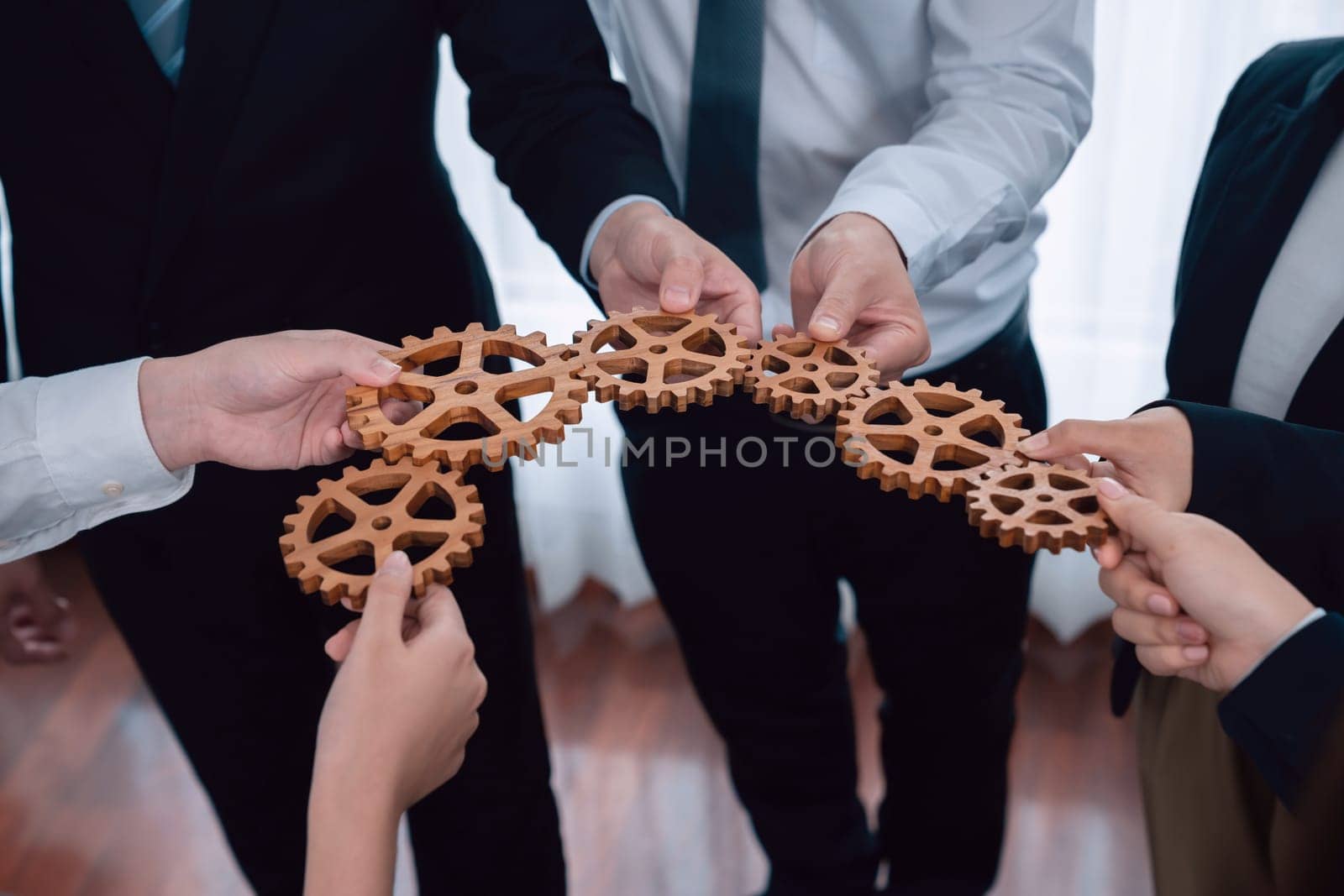 Group of people making chain of gears into collective form for harmony symbol. by biancoblue