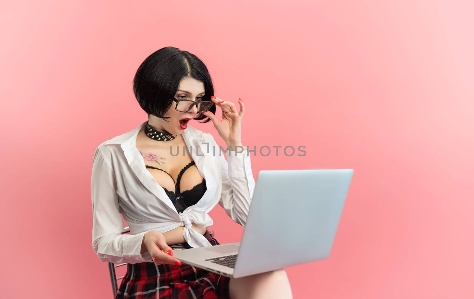 sexy woman with glasses and laptop online-flirting on a pink background copy paste