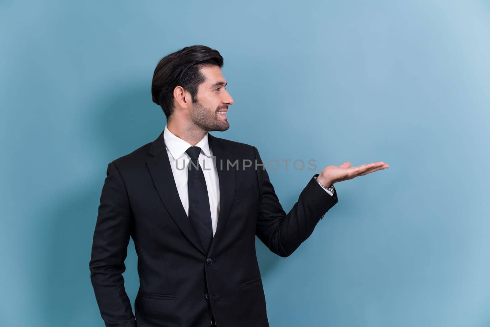 Confident businessman in formal suit making holding hand gesture to indicate promotion or advertising on empty space with excited facial expression and gesture on isolated background. Fervent