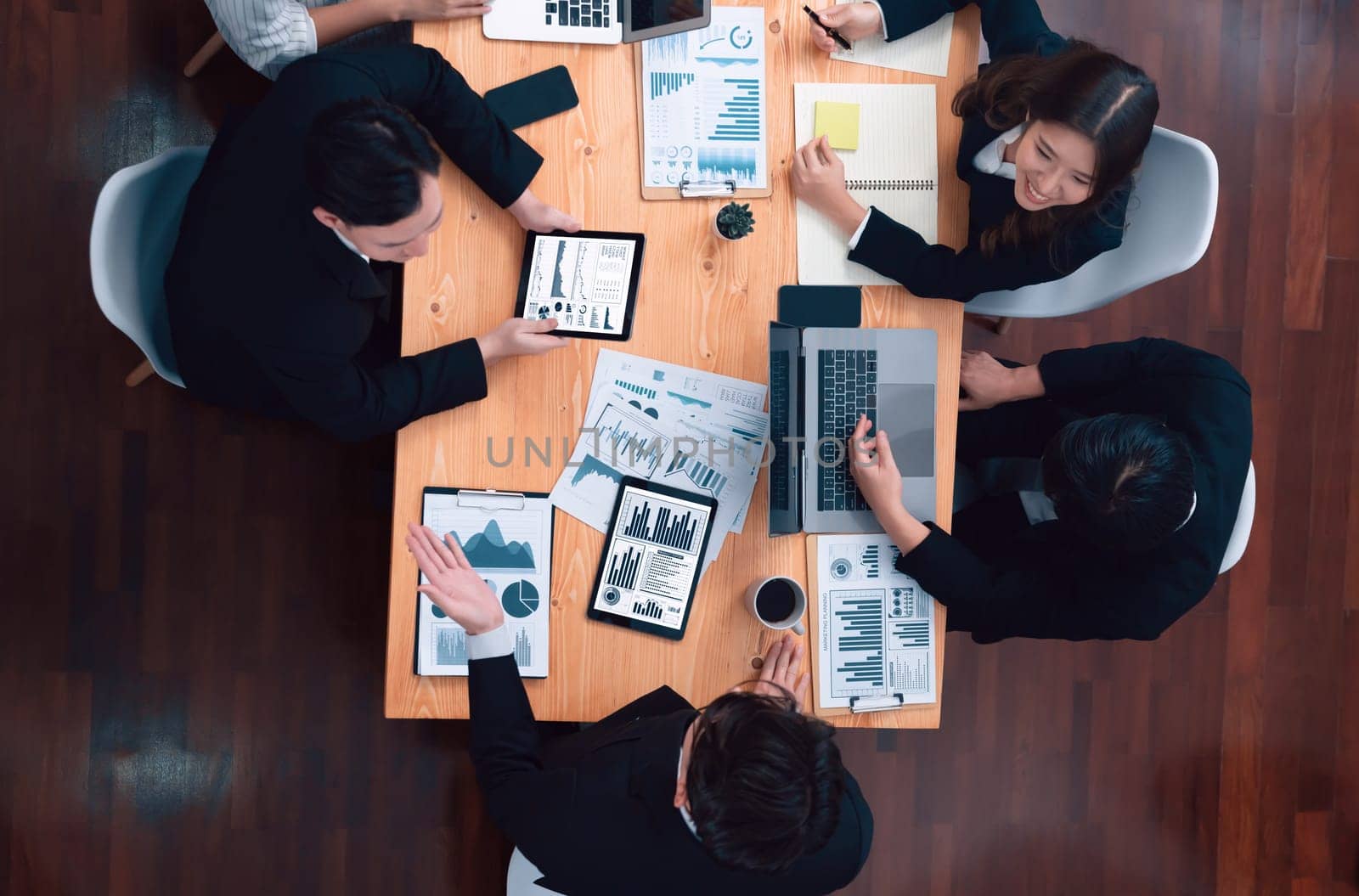 Top-view business team of financial data analysis meeting with business intelligence, report paper and dashboard on laptop for marketing strategy. Business people working together in office of harmony