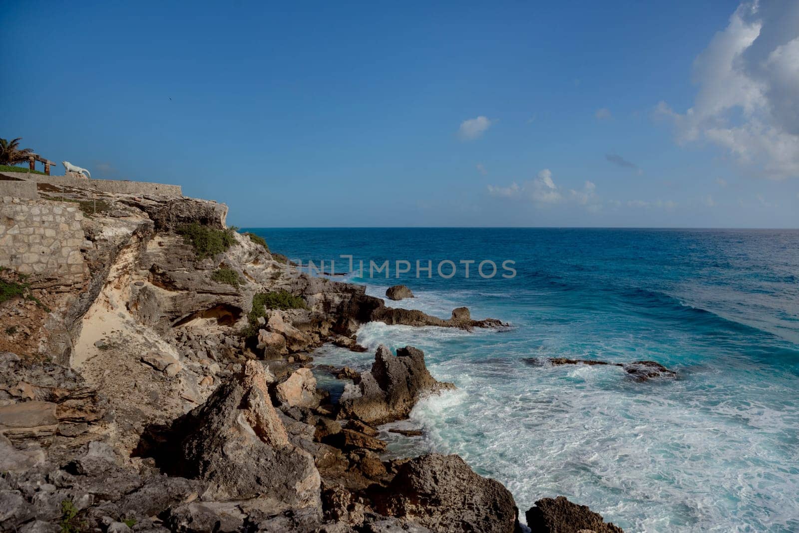 The coastline of the Caribbean Sea with white sand and rocks in Cancun.