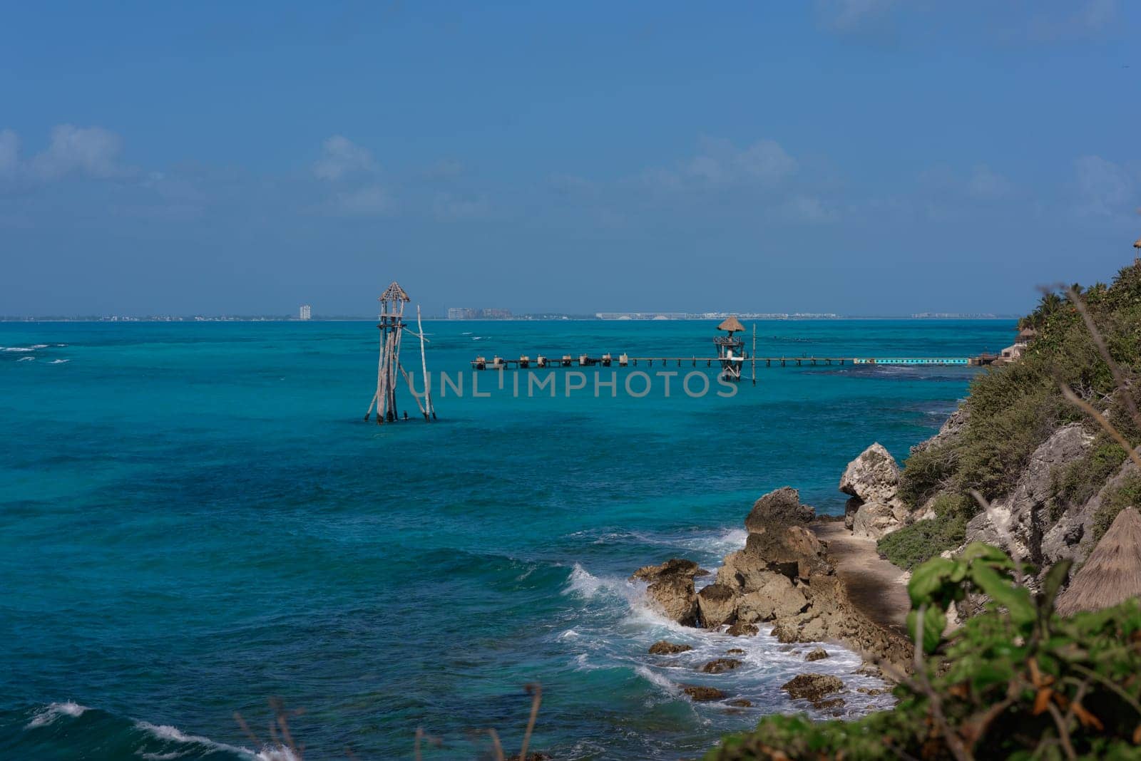 The coastline of the Caribbean Sea with white sand and rocks in Cancun.