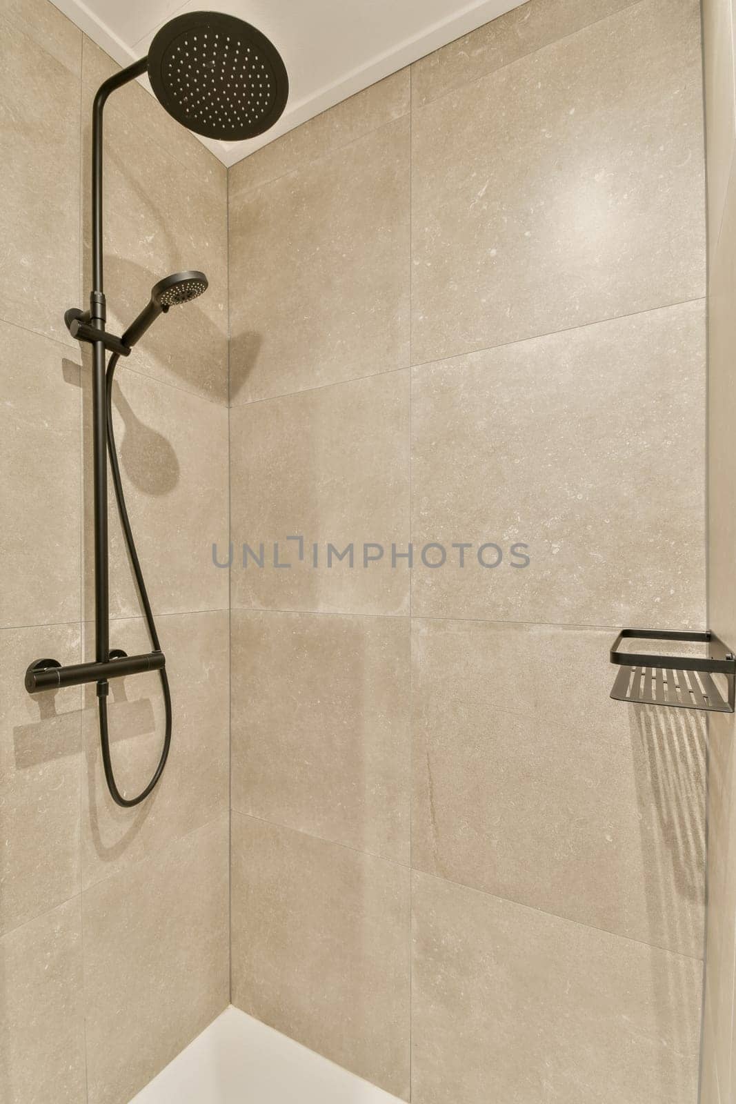 a shower with a shower head in a bathroom by casamedia