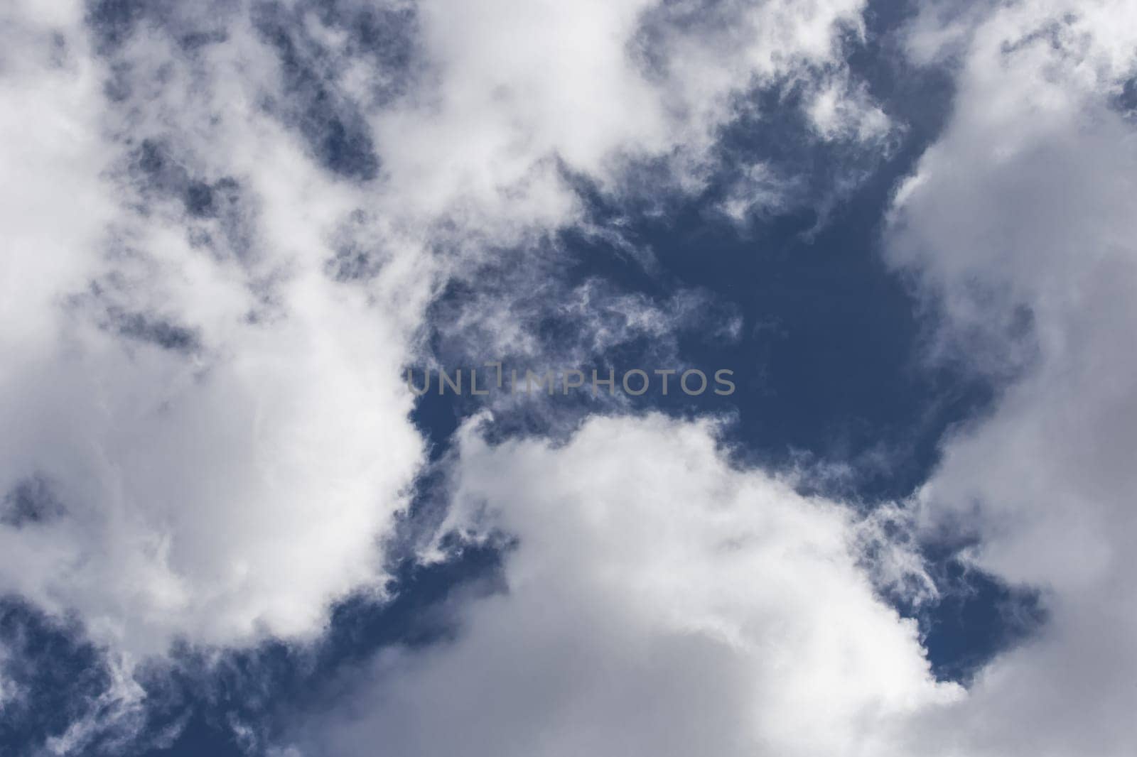 White cumulus clouds against a dark blue sky natural background weather change wind.