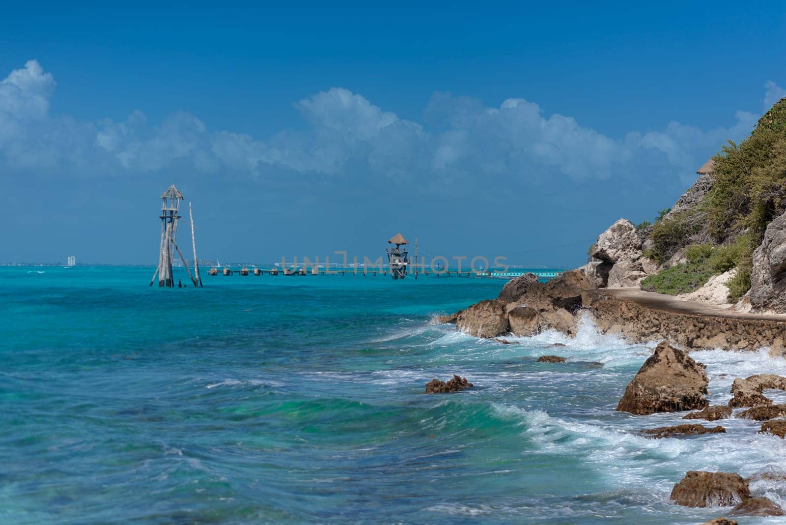 The coastline of the Caribbean Sea with white sand and rocks in Cancun.