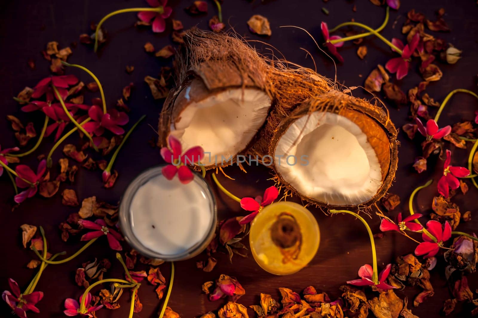 Coconut face mask on the brown colored surface consisting of some coconut milk and olive oil when applied penetrates the skin and exfoliates deeply. Face mask for protection against skin damage. by mirzamlk