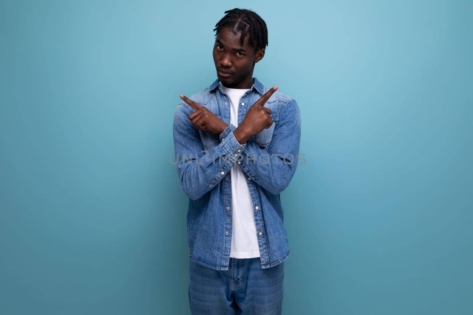 dude african man with curly hair in a denim jacket shows his hands to the sides.