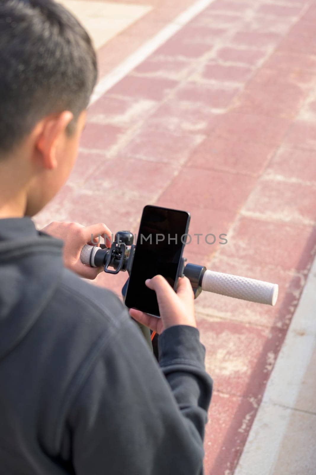 young man on an electric skate using smartphone gps applications by carlosviv