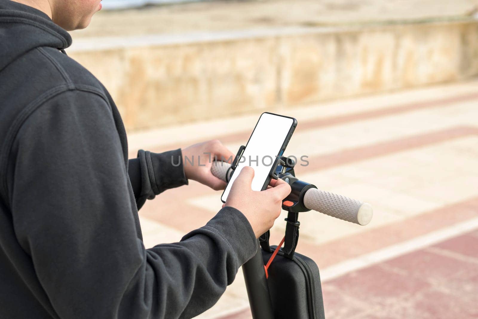 Top side view 14-20 years old riding scooter using mobile phone navigation route outdoors in nature,E-Mobility Urban Leisure Concept