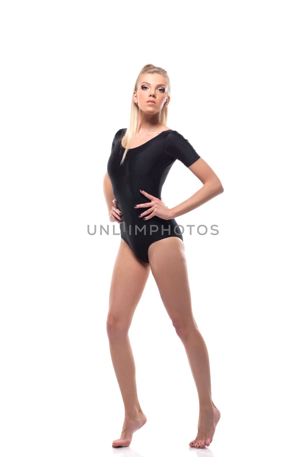 Beautiful sporty girl in black leotard, isolated on white
