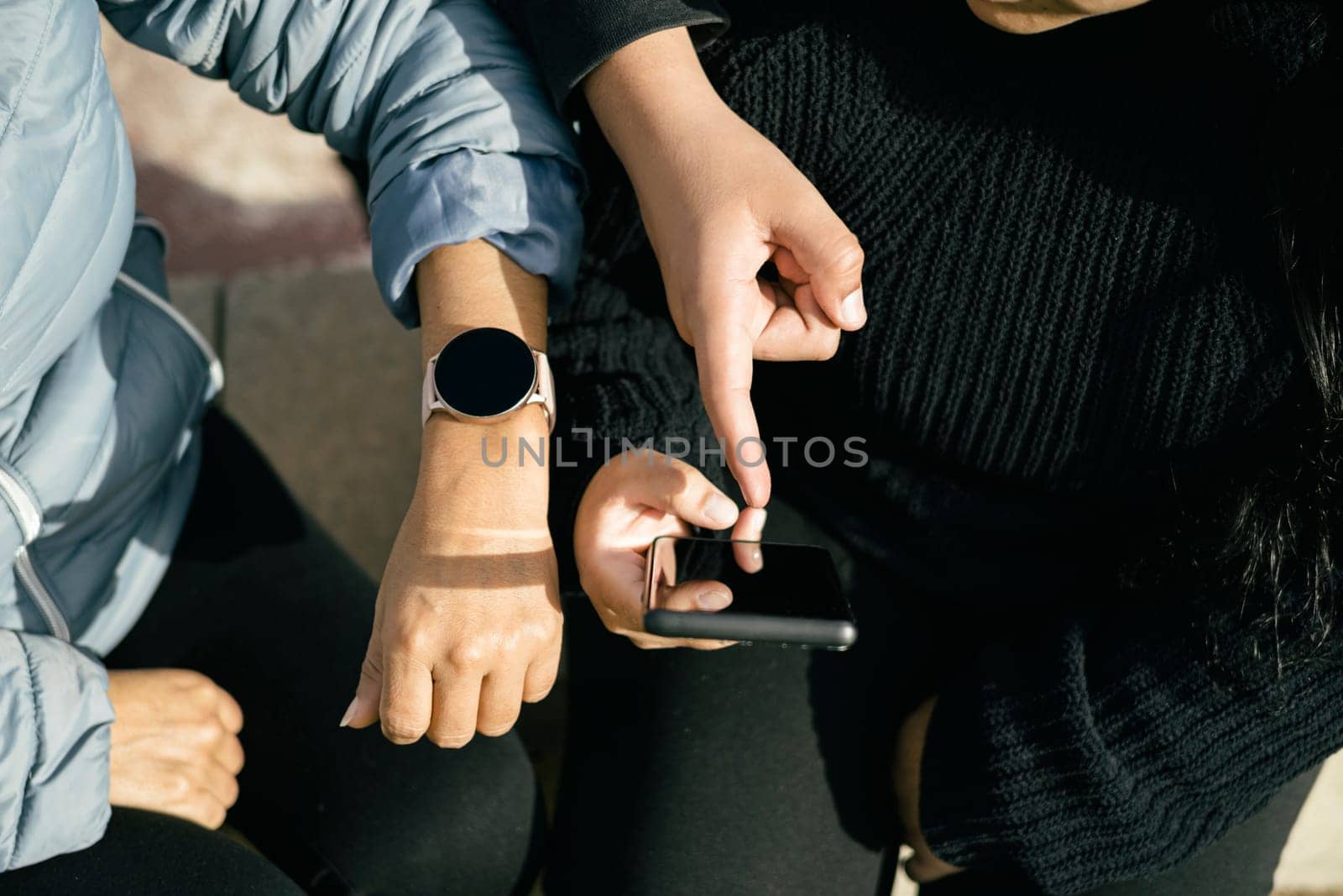 three Latin people using their mobile devices and interacting with each other. The photo is cropped to focus on their hands holding the devices, as they chat and share content with one another. The image captures the modern and tech-savvy lifestyle of the Latin community, and can be used to illustrate topics such as social media, communication, technology, or cultural diversity. The picture is high-quality, with bright colors and clear details that will add a dynamic and engaging visual element to any project.