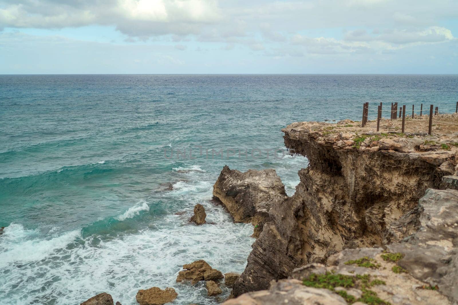 The coastline of the Caribbean Sea with white sand and rocks in Cancun.