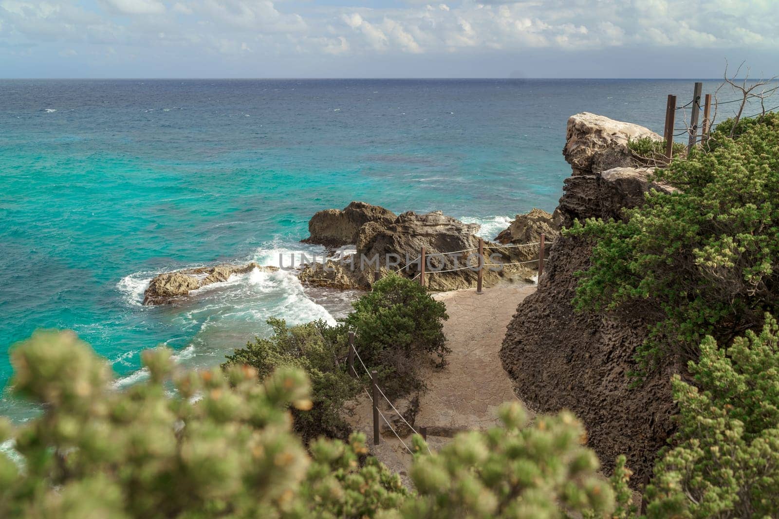 The coastline of the Caribbean Sea with white sand and rocks in Cancun.