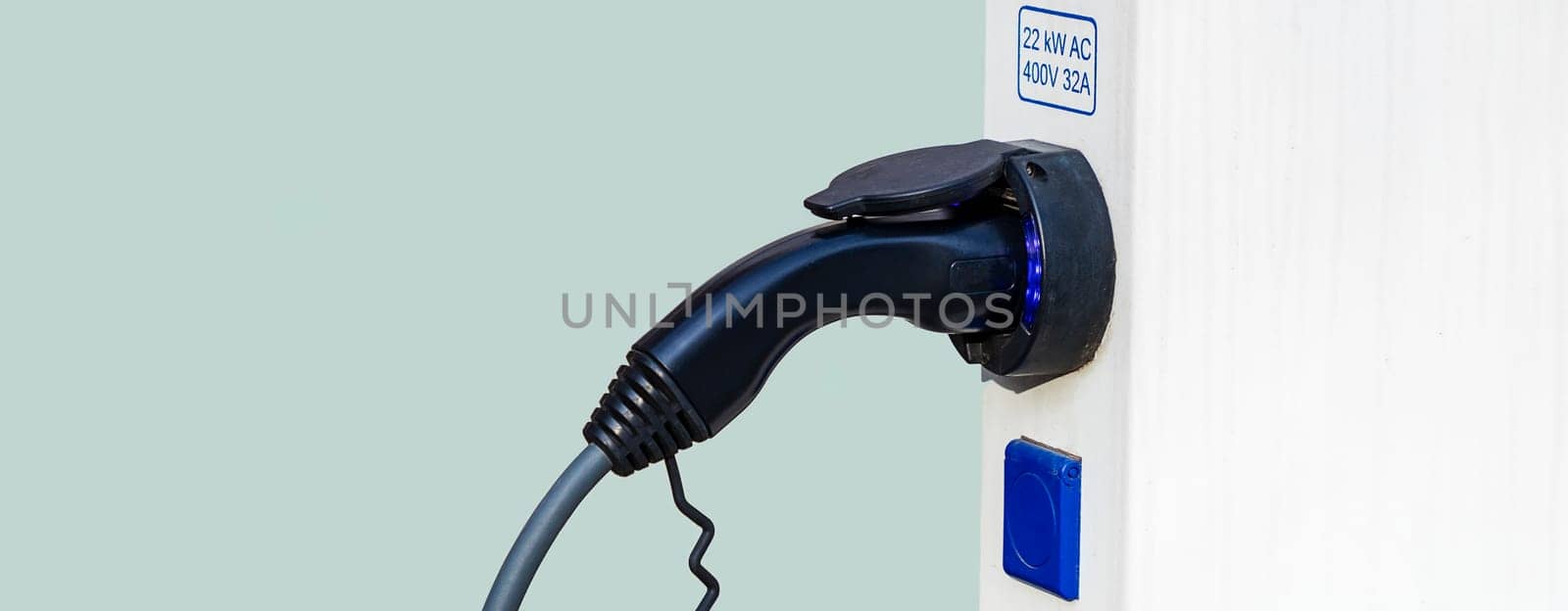 Closeup of charger plug to an electric vehicle from charging station.