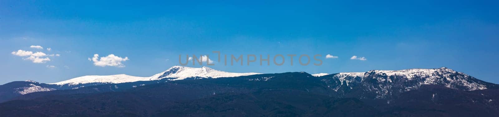 Amazing panorama with snow-capped mountains and hills