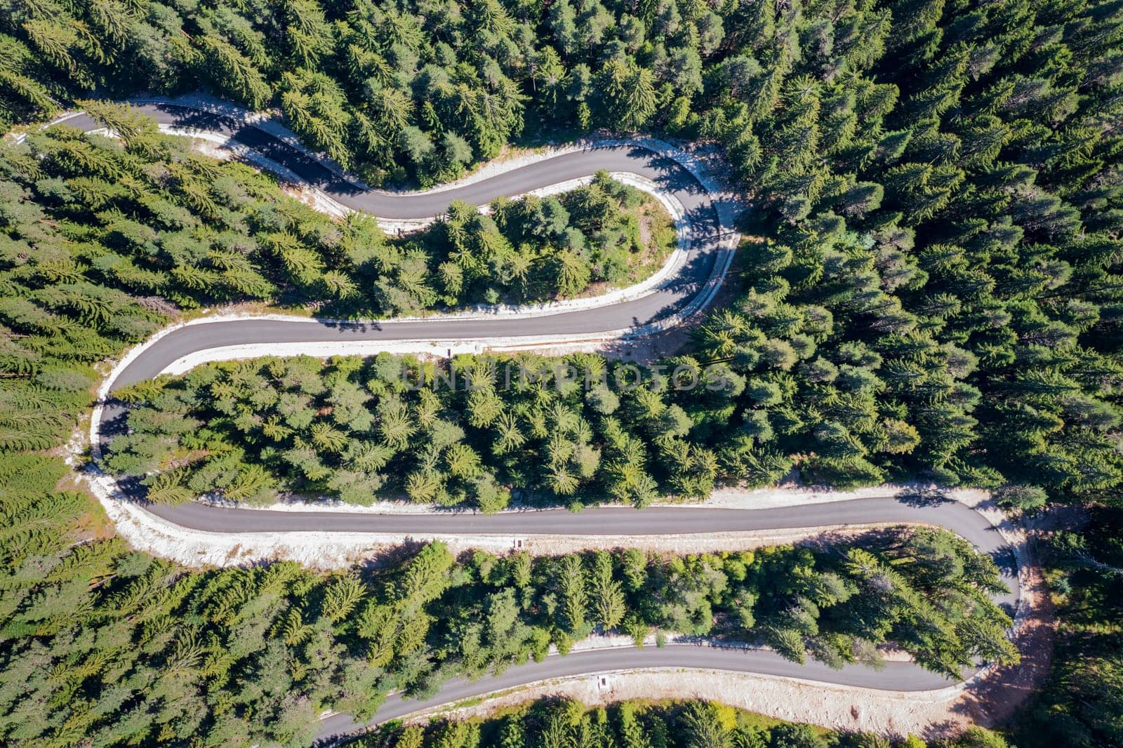 Aerial view from drone of curves of mountain road. Transportation and infrastructure concept